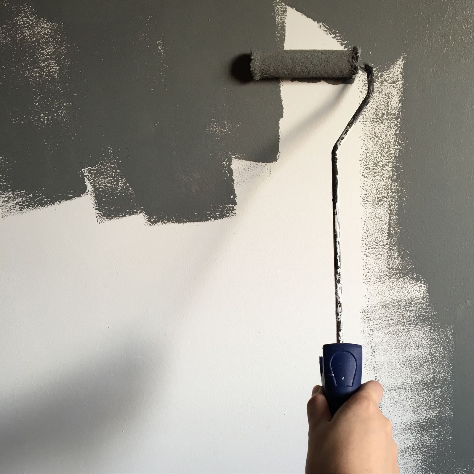 A roller laying a fresh coat of paint on a wall