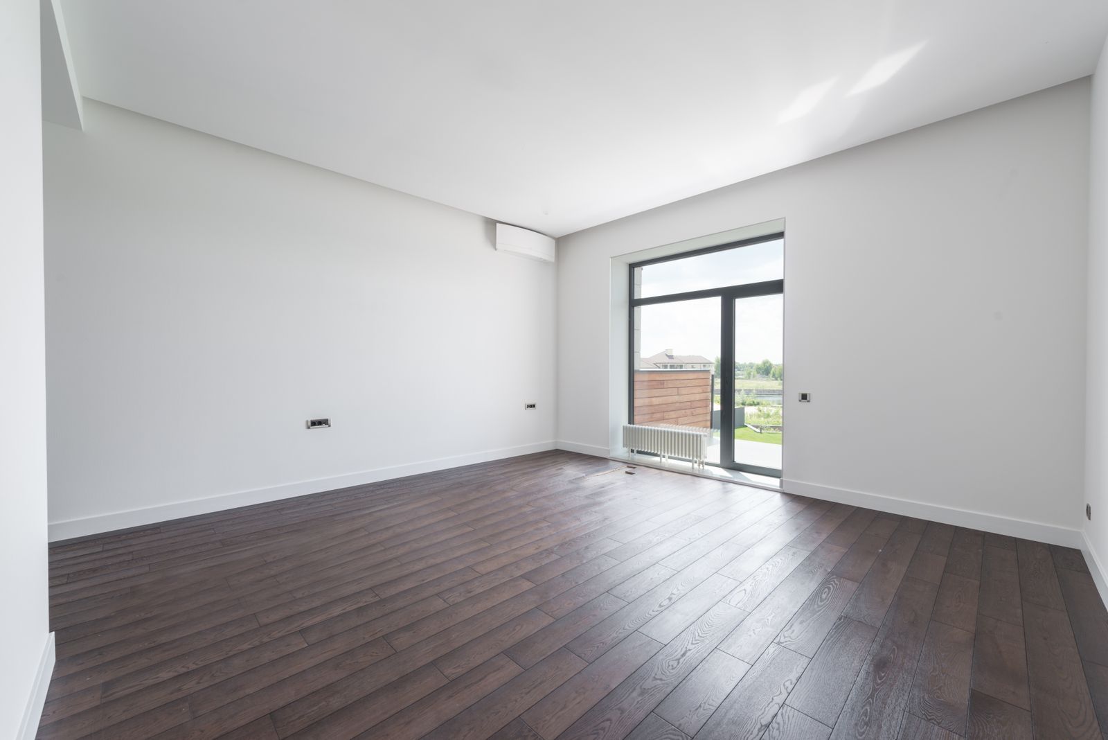 An empty room with crisp white walls and hardwood floors